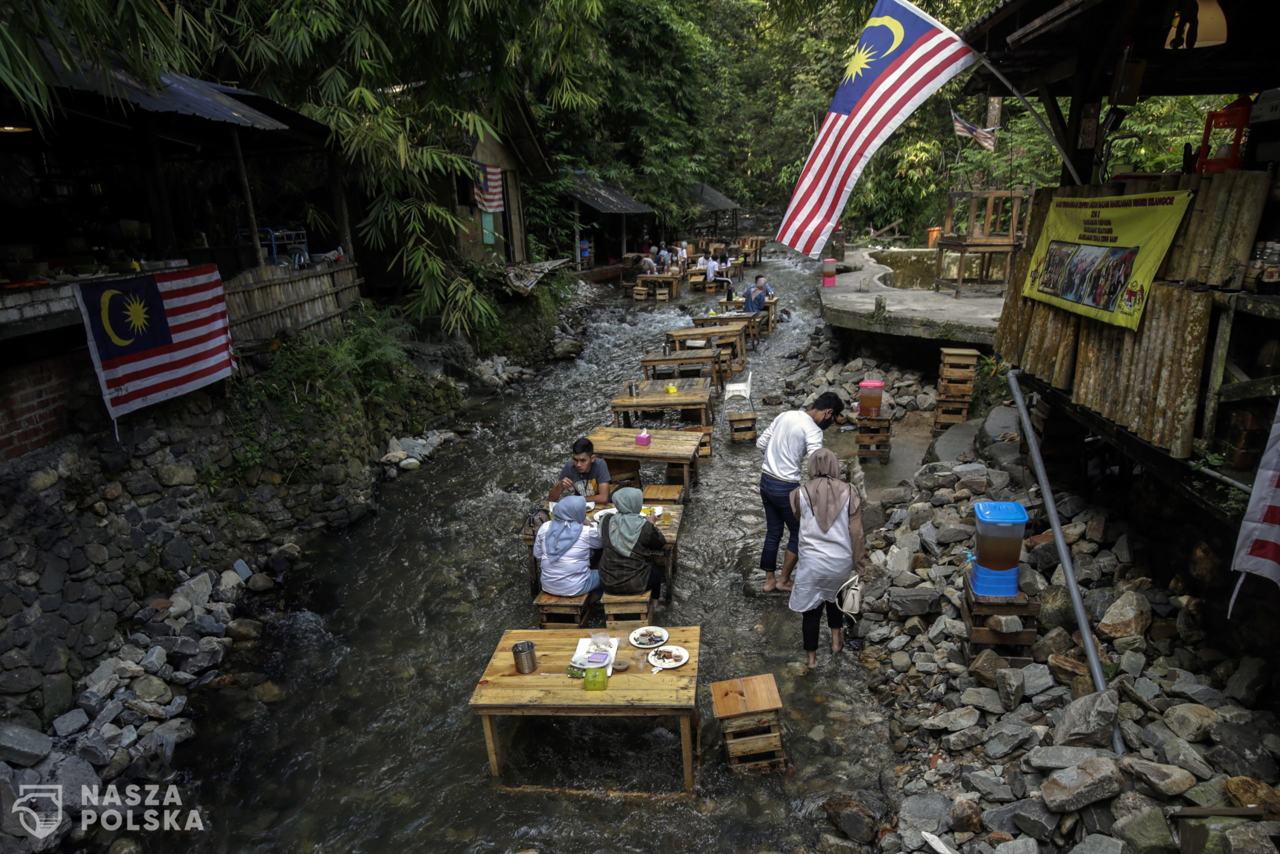epa08708652 Malaysian having their meals in the stream at Kampung Kemensah, Kuala Lumpur, Malaysia, 30 September 2020. In combining adventure with nature and food the BBQ Lamb KL Kemensah restaurant has been serving the meals in the stream since 2017.  EPA/AHMAD YUSNI 
Dostawca: PAP/EPA.