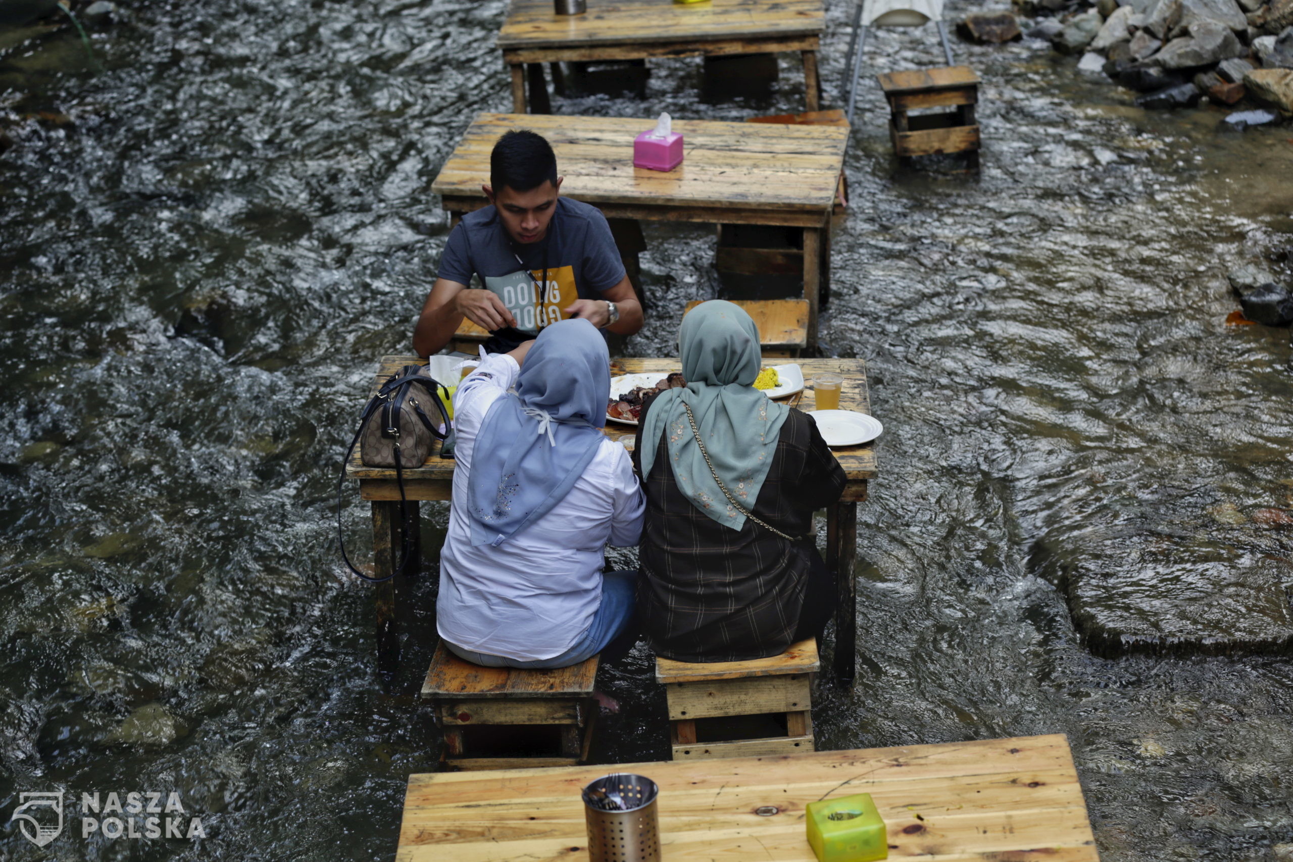 epa08708659 Malaysian having their meals in the stream at Kampung Kemensah, Kuala Lumpur, Malaysia, 30 September 2020. In combining adventure with nature and food the BBQ Lamb KL Kemensah restaurant has been serving the meals in the stream since 2017.  EPA/AHMAD YUSNI 
Dostawca: PAP/EPA.